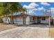 Single story home with desert landscaping, mature trees, and a covered carport at 7022 N 26Th Dr, Phoenix, AZ 85051