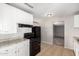 Well-lit kitchen features white cabinetry and contrasting black appliances at 7022 N 26Th Dr, Phoenix, AZ 85051