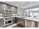 Modern kitchen with stainless steel appliances, gray cabinetry, and a mosaic tile backsplash at 7151 E Rancho Vista Dr # 2007, Scottsdale, AZ 85251