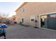 Exterior view of the backyard with sliding glass door, brick paved patio, and access to the home at 7611 S 15Th St, Phoenix, AZ 85042