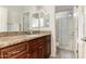 Bathroom with granite countertops, wood cabinets, large mirror, and shower at 7611 S 15Th St, Phoenix, AZ 85042