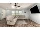 Living room with wood look floors, light walls, ceiling fan, and ample seating at 7611 S 15Th St, Phoenix, AZ 85042