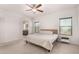 Bright and airy main bedroom with plush carpet, ceiling fan, and a glimpse into ensuite bathroom at 7611 S 15Th St, Phoenix, AZ 85042