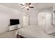 Spacious main bedroom with a TV, a ceiling fan, and an arched entry to ensuite bath at 7611 S 15Th St, Phoenix, AZ 85042