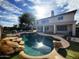 Gorgeous backyard featuring a large pool with rock accents and manicured landscaping at 765 S Ruby Pl, Gilbert, AZ 85296