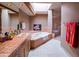 Well-lit bathroom featuring a soaking tub, a skylight and tiled countertops at 8502 E Cave Creek Rd # 10, Carefree, AZ 85377