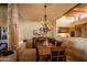 Warm dining room with a wooden table, chandelier, and partial view of the adjacent kitchen area at 8502 E Cave Creek Rd # 10, Carefree, AZ 85377