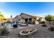 Well-maintained backyard featuring a pool, fire pit, covered patio, and ample space for entertaining at 902 W Desert Valley Dr, San Tan Valley, AZ 85143