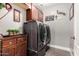 Laundry room with front loading washer and dryer and custom cabinet storage at 902 W Desert Valley Dr, San Tan Valley, AZ 85143