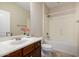 Bathroom with dark wood cabinets, neutral tile flooring and shower/tub combination at 9035 W Quail Track Dr, Peoria, AZ 85383