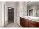 Bathroom with dark wood cabinets, light countertops and neutral tile flooring at 9035 W Quail Track Dr, Peoria, AZ 85383