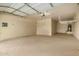 Spacious garage boasting painted walls, a clean epoxy floor, and overhead storage racks at 9035 W Quail Track Dr, Peoria, AZ 85383