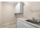 The laundry room features tile floors, a stainless steel sink, ample cabinets, and neutral paint at 9035 W Quail Track Dr, Peoria, AZ 85383