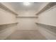 Spacious walk-in closet featuring ample shelving and neutral carpeting at 9035 W Quail Track Dr, Peoria, AZ 85383