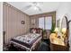 Charming bedroom with striped wallpaper, a quilted bedspread, and a vintage dresser, providing a unique and cozy retreat at 9213 W Clara Ln, Peoria, AZ 85382