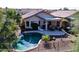 Backyard aerial view featuring a desert landscape, pool, patio with seating, and fenced perimeter at 9796 E Stone Cir Ln, Gold Canyon, AZ 85118