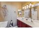 Bathroom featuring double sinks, a large mirror, artistic wall decor and a shower behind glass door at 9796 E Stone Cir Ln, Gold Canyon, AZ 85118