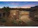 Charming home featuring desert landscaping, a two-car garage, and a warm, inviting facade nestled against a beautiful desert mountain backdrop at 9796 E Stone Cir Ln, Gold Canyon, AZ 85118