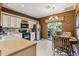 Charming kitchen with white cabinets, stainless steel appliances, and an adjacent dining area leading to an outdoor patio at 9796 E Stone Cir Ln, Gold Canyon, AZ 85118