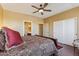 Spacious bedroom with a ceiling fan, wood floors, and a doorway leading to the bathroom at 9796 E Stone Cir Ln, Gold Canyon, AZ 85118