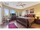 Comfortable main bedroom with a ceiling fan, wood floors, and large windows overlooking the well maintained desert yard at 9796 E Stone Cir Ln, Gold Canyon, AZ 85118