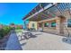 Large back patio features a seating area covered by a modern pergola, table and a partial lawn at 10039 W Jasmine Trl, Peoria, AZ 85383