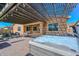 Outdoor living space featuring a hot tub, comfortable seating, and a stylish pergola for shaded relaxation at 10039 W Jasmine Trl, Peoria, AZ 85383