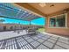 Shaded patio with a pergola offering an outdoor dining area and views of the landscaped backyard at 10039 W Jasmine Trl, Peoria, AZ 85383