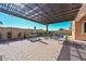 Spacious backyard featuring a cozy patio under a pergola, seating, and a well-maintained garden at 10039 W Jasmine Trl, Peoria, AZ 85383