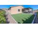 Beautiful backyard featuring artificial turf, a pergola-covered patio, and mature landscaping at 10039 W Jasmine Trl, Peoria, AZ 85383