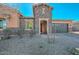 Charming single-story home featuring a stone facade, inviting entry gate, and attached two-car garage at 10039 W Jasmine Trl, Peoria, AZ 85383