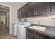Well-equipped laundry room featuring ample cabinet space, modern washer, dryer, and a utility sink at 10039 W Jasmine Trl, Peoria, AZ 85383