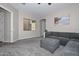 Inviting living room featuring plush gray carpeting, a large sectional sofa, and a calming beach themed art piece at 10039 W Jasmine Trl, Peoria, AZ 85383