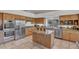 Spacious kitchen features wooden cabinets, stainless steel appliances and large island with marble countertop at 10040 E Happy Valley Rd # 249, Scottsdale, AZ 85255
