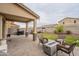 Backyard includes a covered patio, paver patio, artificial turf, and a built-in fire pit at 10822 W Taylor St, Avondale, AZ 85323