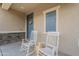 Inviting front porch featuring rocking chairs, stone accents, and a welcoming entrance at 10822 W Taylor St, Avondale, AZ 85323