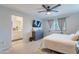 This main bedroom features a ceiling fan, a TV above a grey dresser, and ensuite access to the primary bathroom at 10822 W Taylor St, Avondale, AZ 85323