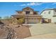 Two-story tan home featuring a two car garage, desert landscaping, and stone accents at 14104 N 146Th Ln, Surprise, AZ 85379