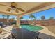 Covered patio area with a ceiling fan overlooking the pool and rock waterfall feature at 14104 N 146Th Ln, Surprise, AZ 85379