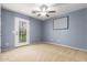 Comfortable bedroom with neutral carpet, ceiling fan, and access to the backyard at 1422 S Colt Dr, Gilbert, AZ 85296