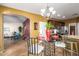 Open-concept kitchen with a chandelier, dark wood cabinets, and adjacent living area at 1422 S Colt Dr, Gilbert, AZ 85296