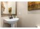 Stylish powder room featuring a pedestal sink, decorative mirror, and neutral wall color at 1422 S Colt Dr, Gilbert, AZ 85296