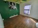 Empty bedroom featuring hardwood floors, a window, and green accent wall at 1637 E Brill St, Phoenix, AZ 85006