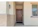 Inviting front entryway features a brown front door, neutral stucco walls, and a covered porch at 16959 W Diana Ave, Waddell, AZ 85355