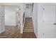 Hallway with wood-look flooring and carpeted stairs with dark railing at 16959 W Diana Ave, Waddell, AZ 85355