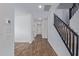 Hallway with wood-look flooring, white walls, and dark stairs leading to upper level at 16959 W Diana Ave, Waddell, AZ 85355