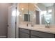 Bright bathroom featuring a double sink vanity with gray cabinets and a large mirror at 17353 W Via De Luna Dr, Surprise, AZ 85387