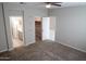 Bedroom with neutral carpeting, open closet space, and an accessible ensuite bathroom at 17353 W Via De Luna Dr, Surprise, AZ 85387