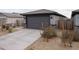 Contemporary home featuring a gray garage door, desert landscaping, and modern exterior lighting at 17353 W Via De Luna Dr, Surprise, AZ 85387