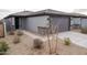 Attractive single-story home with gray exterior, complemented by desert landscaping and a spacious driveway at 17353 W Via De Luna Dr, Surprise, AZ 85387